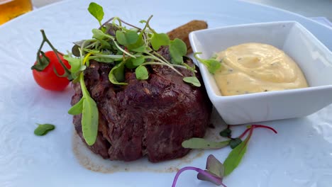 filete jugoso con salsa de bearnaise, ensalada de microverdes y un tomate cereza en un restaurante de lujo, almuerzo cena, tiro de 4k