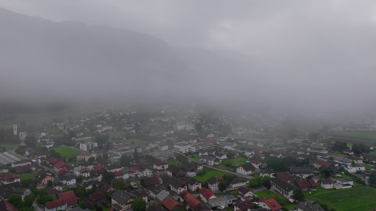 안개 가 많은 날 에 스위스 알프스 의 한 마을 의 공중 사진