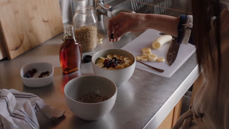 young asian woman eating breakfast in kitchen enjoying healthy oatmeal cereal mixed with fruit relaxing at home on weekend