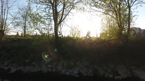 bailarín haciendo un salto en un camino con árboles, puesta de sol en el fondo. francia