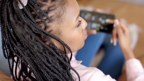 a young african american woman holding smartphone