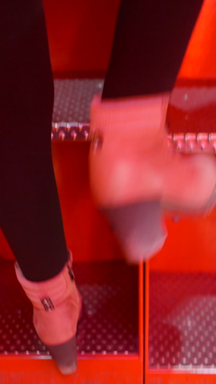 Person climbing red stairs in boots