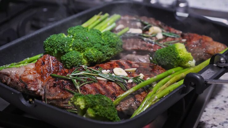 Cooking beef on grill frying pan on gas oven, closeup