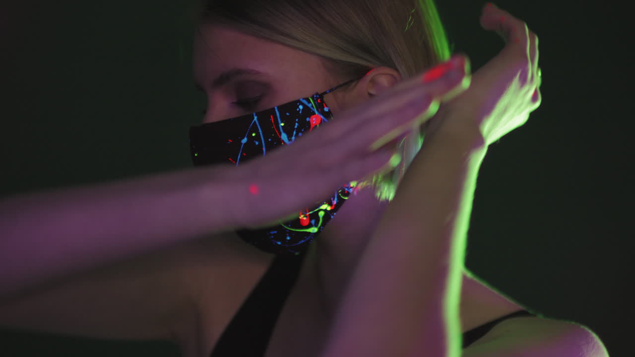 hermosa mujer con máscara fluorescente bailando
