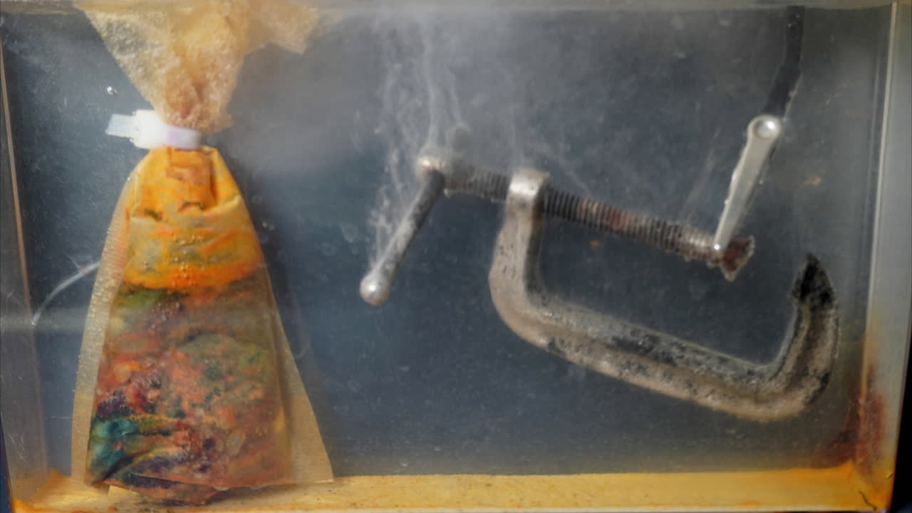 Rusty c-clamp with new metal replacing corrosion during electrolytic cleaning. Timelapse