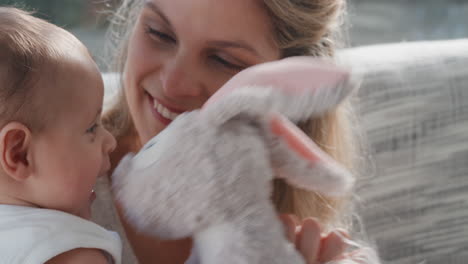 happy mother playing with baby at home loving mom playfully showing teddy bear toy having fun with parent smiling enjoying motherhood 4k footage