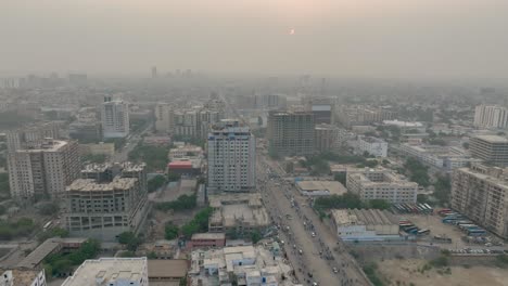 Aerial-drone-panning-shot-from-left-to-right-over-heavy-traffic-along-MA-Jinnah-road,-Karachi,-Pakistan-during-evening-time