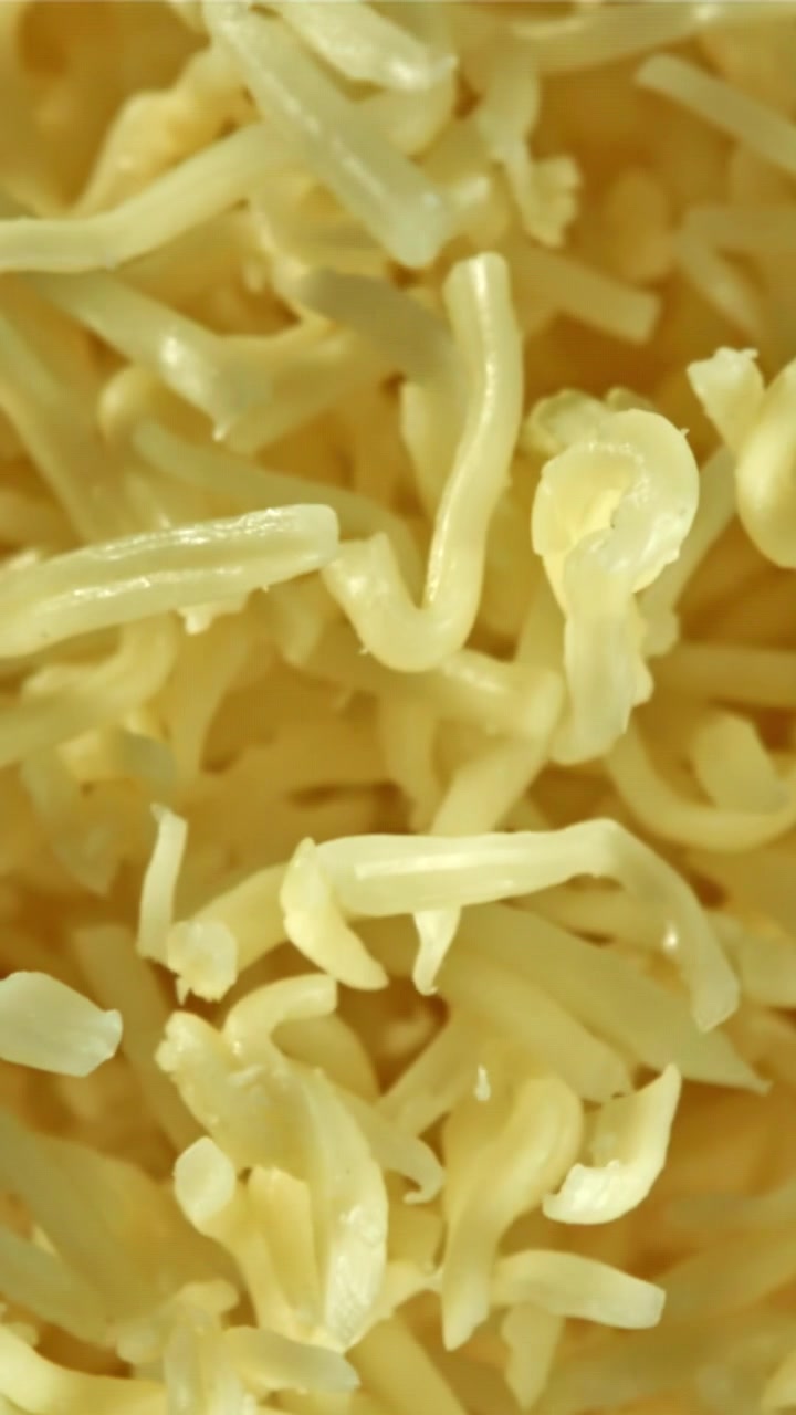 Ripresa macro di formaggio grattugiato che entra a fuoco