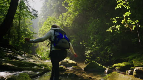 lost in the forest a woman is walking along a stream in the forest her legs are wet beautiful rays o