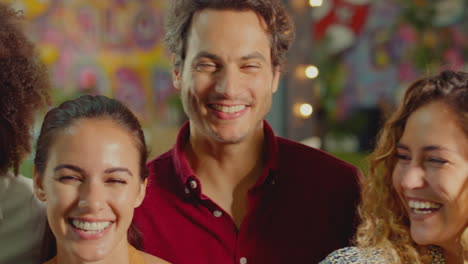 retrato de un grupo de amigos multiculturales sonrientes disfrutando de una noche en un bar o club juntos