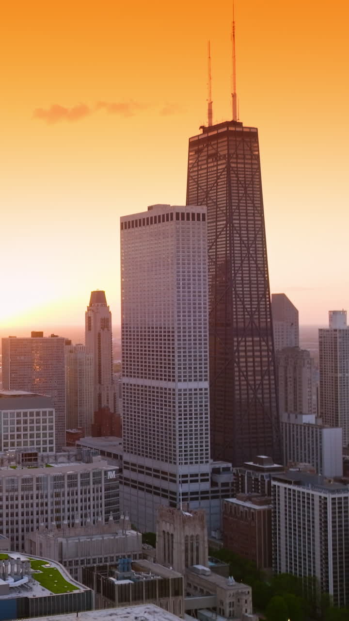 Beautiful yellow sky over fantastic buildings of Chicago. Drone footage raising over the metropolis at sunset. Vertical video