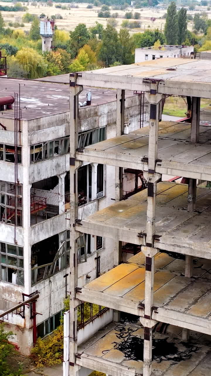 Empty unfinished industrial building. Exterior of abandoned building of an old factory without windows. Ruined architecture after war times.. Vertical video