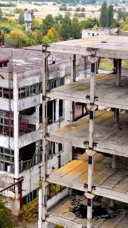 empty unfinished industrial building. exterior of abandoned building of an old factory without windows. ruined architecture after war times.. vertical video