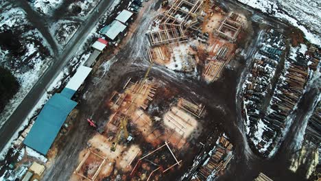 from forest to home: aerial view of a log-home construction in the snowy wilderness of british columbia, canada