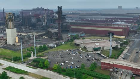 Ford-Rogue-Center-entrance-and-factory-on-rainy,-polluted-day