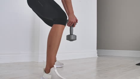 young fitness woman doing squat with dumbbells in hands.