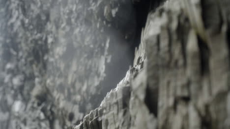 rocky wall with unique hexagonal pattern in a wet cave in iceland