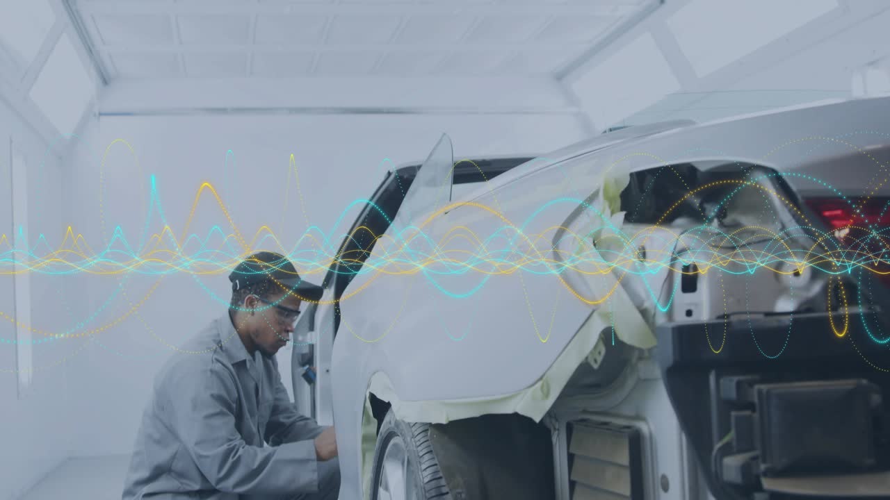 Auto tech leaning over rear panel, applying masking tape with audio wave running, prepping paint