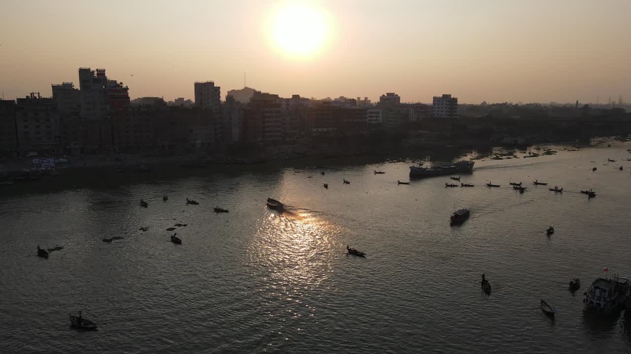 puesta de sol en el río buriganga con barcos y vistas a la ciudad de dhaka