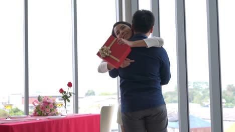 romantic couple giving gift to lover at restaurant