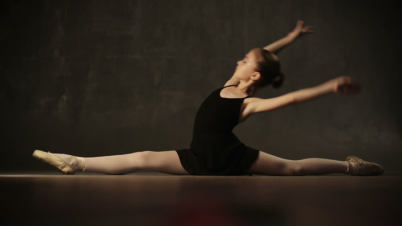 Young beautiful girl ballerina against studio background
