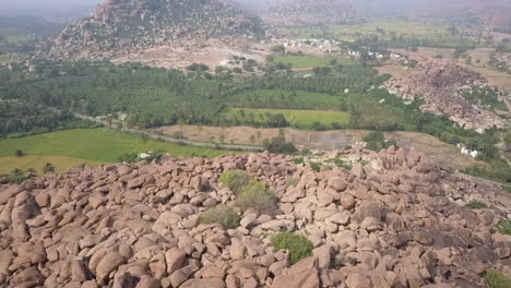 Antena-Desciende-A-La-Montaña-De-Rocas-Gigantes-De-Piedra-En-Hampi,-India