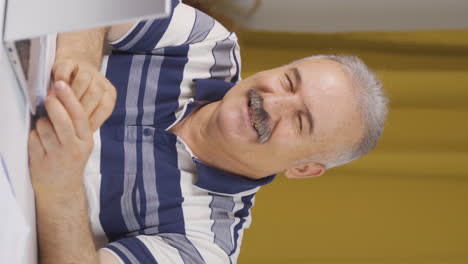 vertical video of home office worker old man winks at camera.