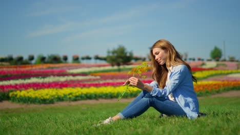 Schönes-Mädchen,-Das-An-Sommertagen-Auf-Gras-Sitzt.-Entspanntes-Mädchen,-Das-Wilde-Blumen-Genießt