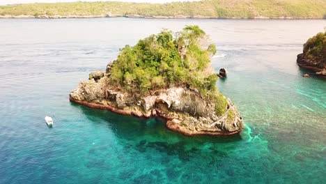 Drone-circling-Crystal-Bay-Island-in-Nusa-Penida,-Bali,-Indonesia