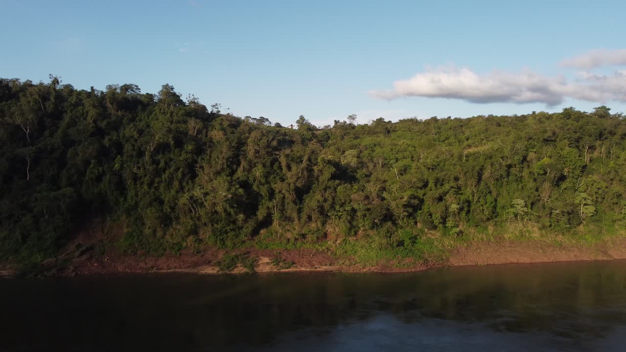 exuberantes orillas del río iguazú en un día soleado en la frontera entre brasil y argentina, aérea lateralmente