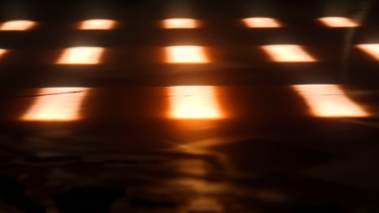 Vídeo abstrato com uma vista em ângulo baixo de luzes quentes e brilhantes, criando um padrão borrado e dinâmico.