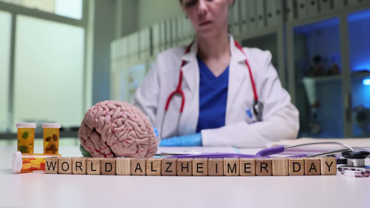 Medical setup with 'World Alzheimer Day' blocks, brain model, and doctor in background