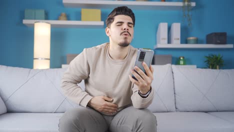 Starving-young-man-entering-food-ordering-app-on-phone.