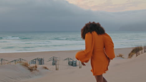 Mujer-Escapando-De-La-Playa-De-Arena-Frente-Al-Cielo-Nublado-Gris.-Chica-Corriendo-A-La-Orilla-Del-Mar.