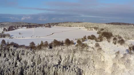 Aerial-timelapse-of-a-winter-landscapes-with-driving-cars-at-the-snowy-background