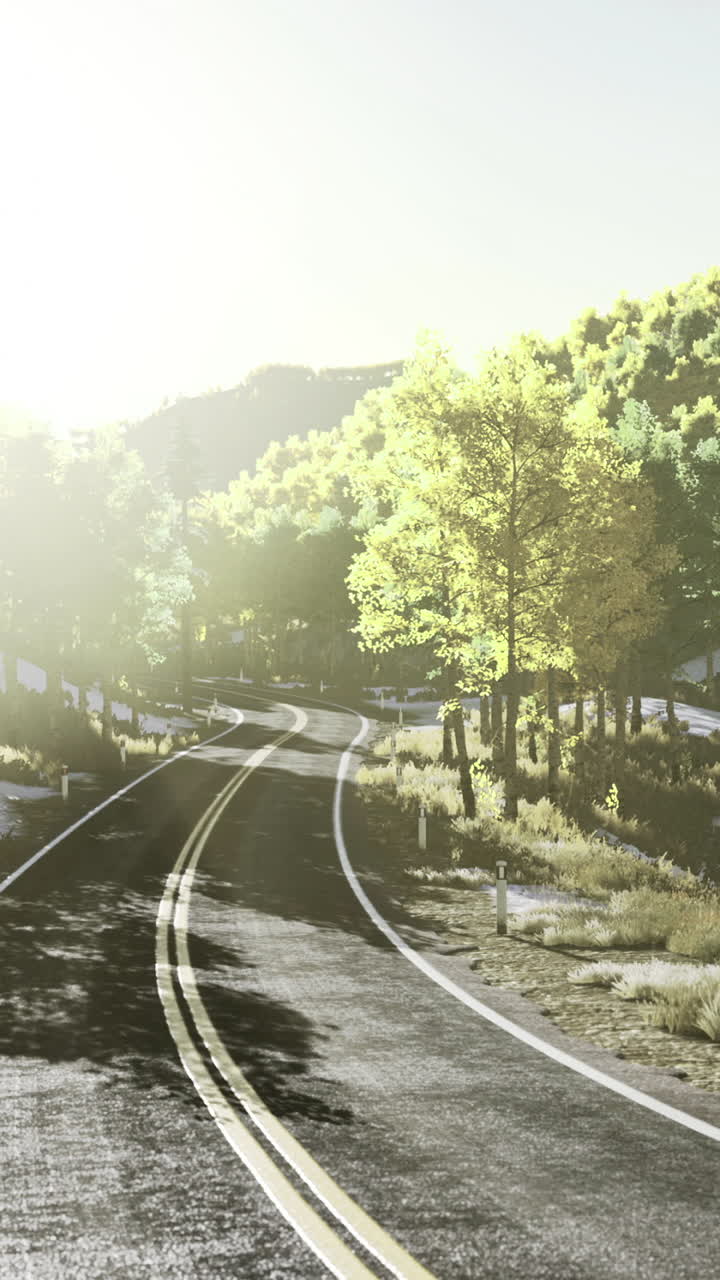 Serene mountain road winding through a vibrant autumn landscape at dawn