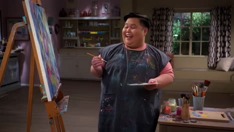 man happily painting in his art studio