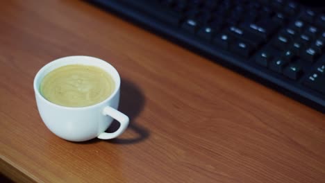 una taza de café en una taza blanca sobre fondo de madera