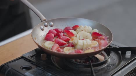 a sizzling hot pan frying fresh fruit in slow motion