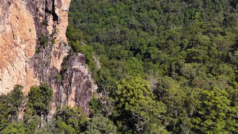 aerial footage capturing the lush greenery and striking rock formations of nimbin, nsw, australia under bright daylight
