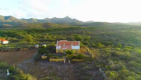 Landhuis-Y-Santa-Cruz-Manor,-Curazao-Al-Atardecer,-Plataforma-Rodante-Con-Drones-En-ángulo-Lateral-Desde-La-Carretera