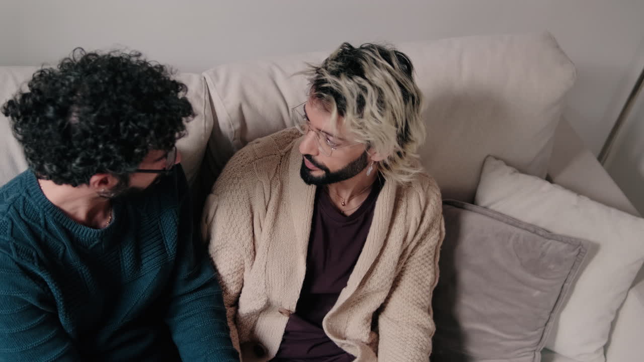 Gay Couple Talking on Sofa at Home