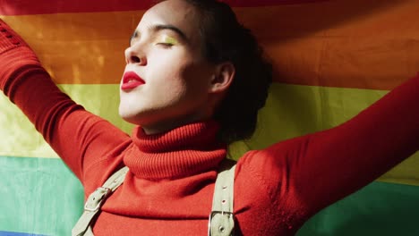 mujer transgénero caucásica no binaria que sostiene la bandera lgbt