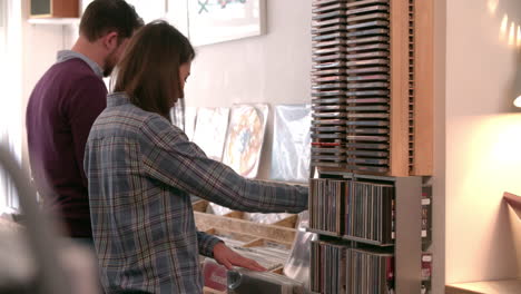 dos personas revisando registros en una tienda de discos