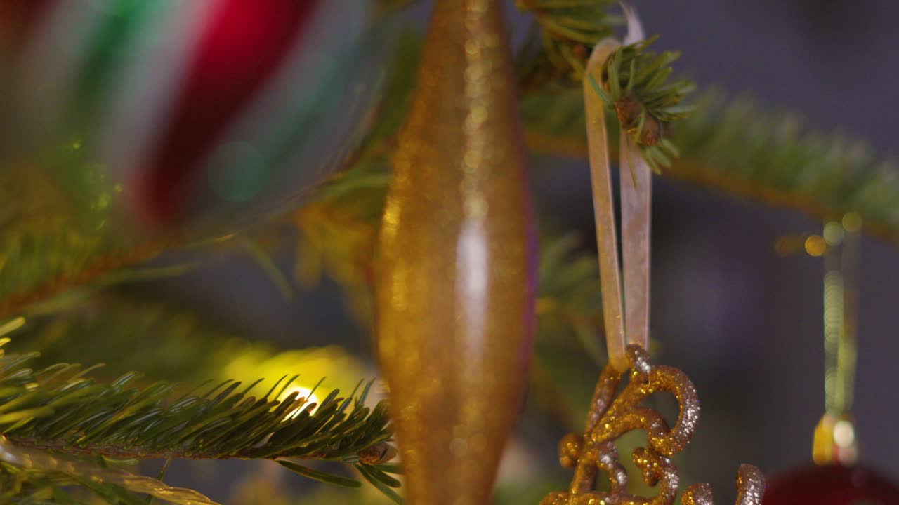 Close Up with Shallow Depth of Field of Christmas Fir Tree with Bourballs and Bright Xmas Lights on Branches. Holidays Festive Seasonal Footage 4K Video Background.