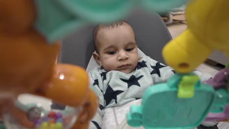 a charming scene of a 4-month-old engages joyfully in a baby bouncer, exploring the world of play with delightful toys