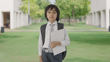 Confident-Indian-school-boy-standing-with-books