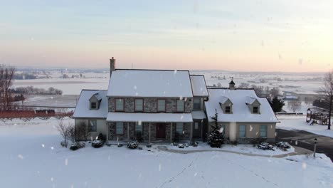 aerial establishing shot of family home during winter snowstorm