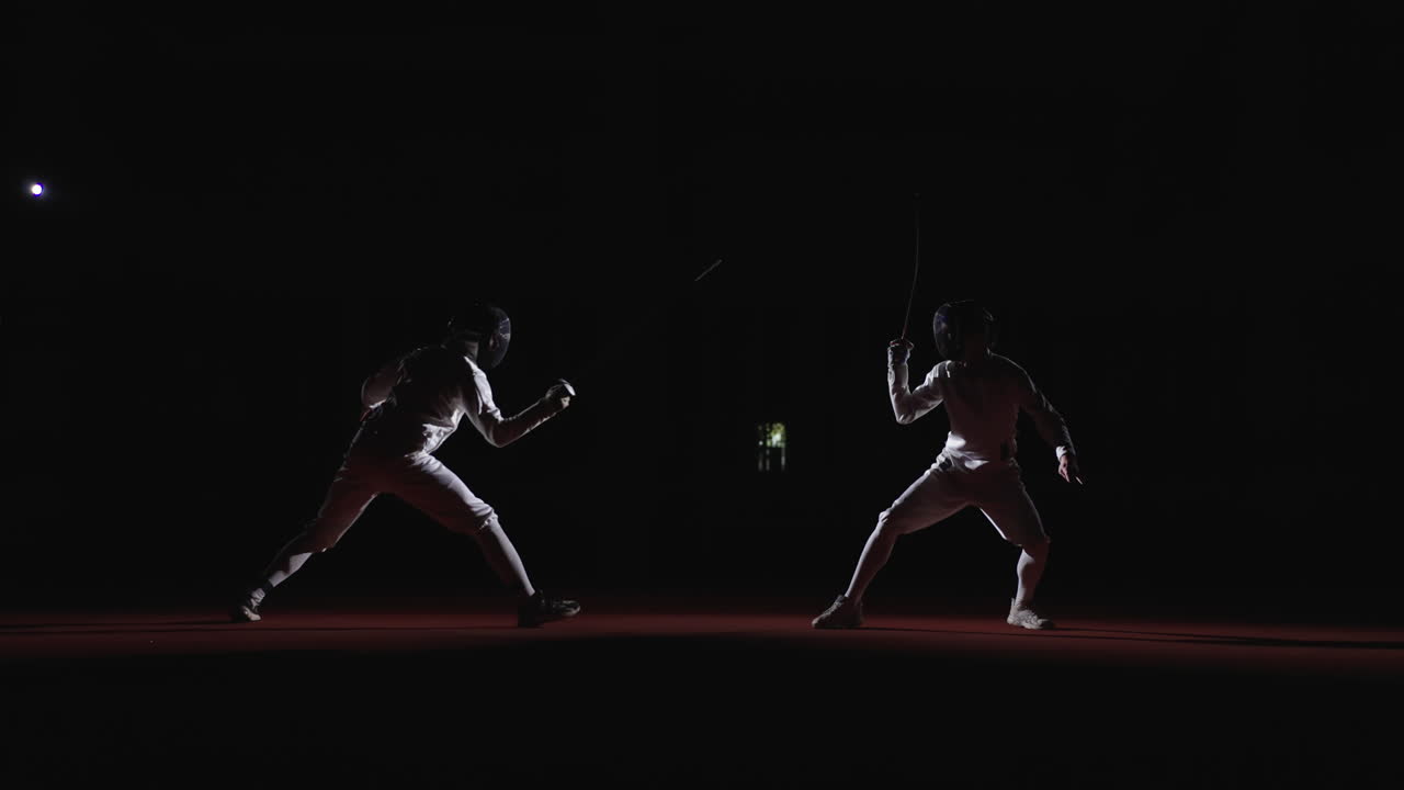 Two fencers compete in a match