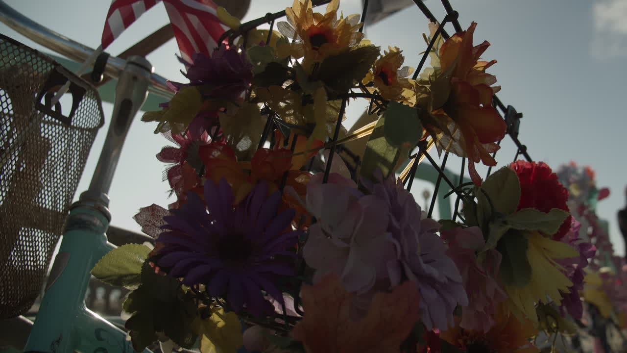 Cinematic slow motion shot of bicycle covered in flowers with sun beams peaking through